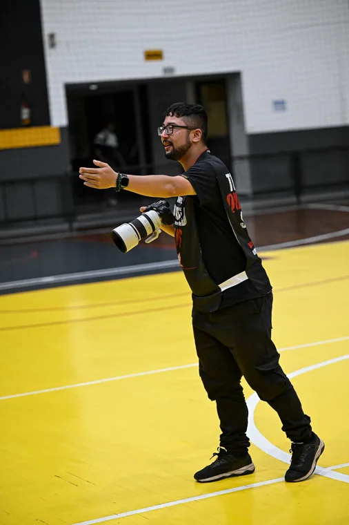 Fotógrafo acompanhando a ação na quadra